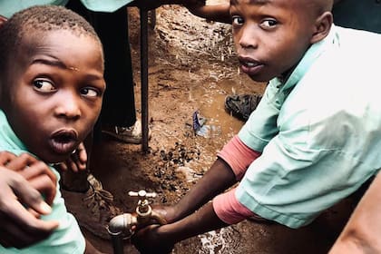 Los niños de la escuela rural de Kangundo, en Kenia, acceden a una canilla con agua