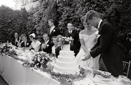 Los novios cortan la torta de bodas de cinco pisos y casi un metro de altura, elaborada por la pastelería familiar de los Kennedy, Plourdes Bakery, en Massachussetts.