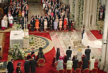Los novios escuchan, tomados de la mano, al coro Príncipe de Asturias ante el altar de la virgen de Atocha, donde depositaron el ramo de la novia. Don Felipe tuvo que esperar 20 minutos a que llegaran. El retraso no fue culpa de la novia: con la alfombra empapada por la lluvia, el servicio de protocolo tuvo que buscar una solución para que la novia no se mojara. Ella y sus damas de honor llegaron en un coche, y los pajes, en un monovolumen