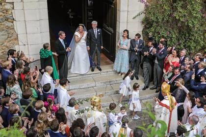 Los novios salen de la iglesia Saint-Trophyme entre aplausos y vítores.