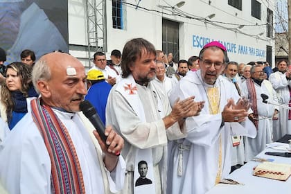 Los padres Lorenzo "Toto" de Vedia y José María "Pepe" Di Paola, junto al obispo Gustavo Carrara, en la misa de desagravio a Francisco, en la parroquia Virgen de los Milagros de Caacupé, de Barracas