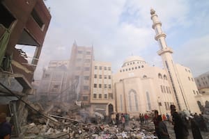 Los palestinos inspeccionan los daños del edificio destruido después de los ataques aéreos israelíes en Khan Younis, Franja de Gaza