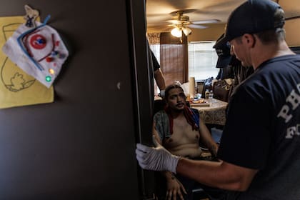 Los paramédicos de la Estación 30 del Departamento de Bomberos de Phoenix atienden a Alex Guerrero, quien se desplomó en el suelo de su casa debido al calor, en Phoenix, Arizona, el sábado 15 de julio de 2023.