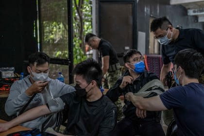 Los participantes en una sesión de entrenamiento de médicos de combate aprenden a envolver vendajes para detener el sangrado de una herida en Taipei, Taiwán, el 28 de mayo de 2022. (Lam Yik Fei/The New York Times)