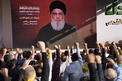 Los partidarios del grupo Hezbollah, respaldado por Irán, levantan los puños y aplauden cuando el líder de Hezbollah, Sayyed Hassan Nasrallah, aparece a través de un video, el 3 de noviembre de 2023