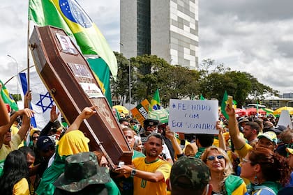 Los partidarios del presidente brasileño Jair Bolsonaro se manifiestan con un ataúd con el retrato del ex ministro de Justicia brasileño Sergio Moro, durante una manifestación en Brasilia el 17 de mayo de 2020, en medio de la pandemia de coronavirus
