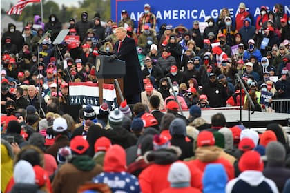 Los partidarios escuchan mientras el presidente de los Estados Unidos, Donald Trump, habla en un mitin "Make America Great Again" en el Aeropuerto Internacional del Condado de Oakland, el 30 de octubre de 2020, en Waterford Township, Michigan.