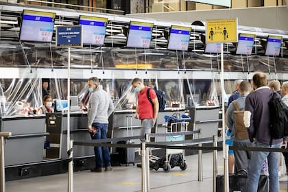 Los pasajeros hacen cola en el mostrador de facturación del aeropuerto de Schiphol en Ámsterdam, el 15 de junio de 2020