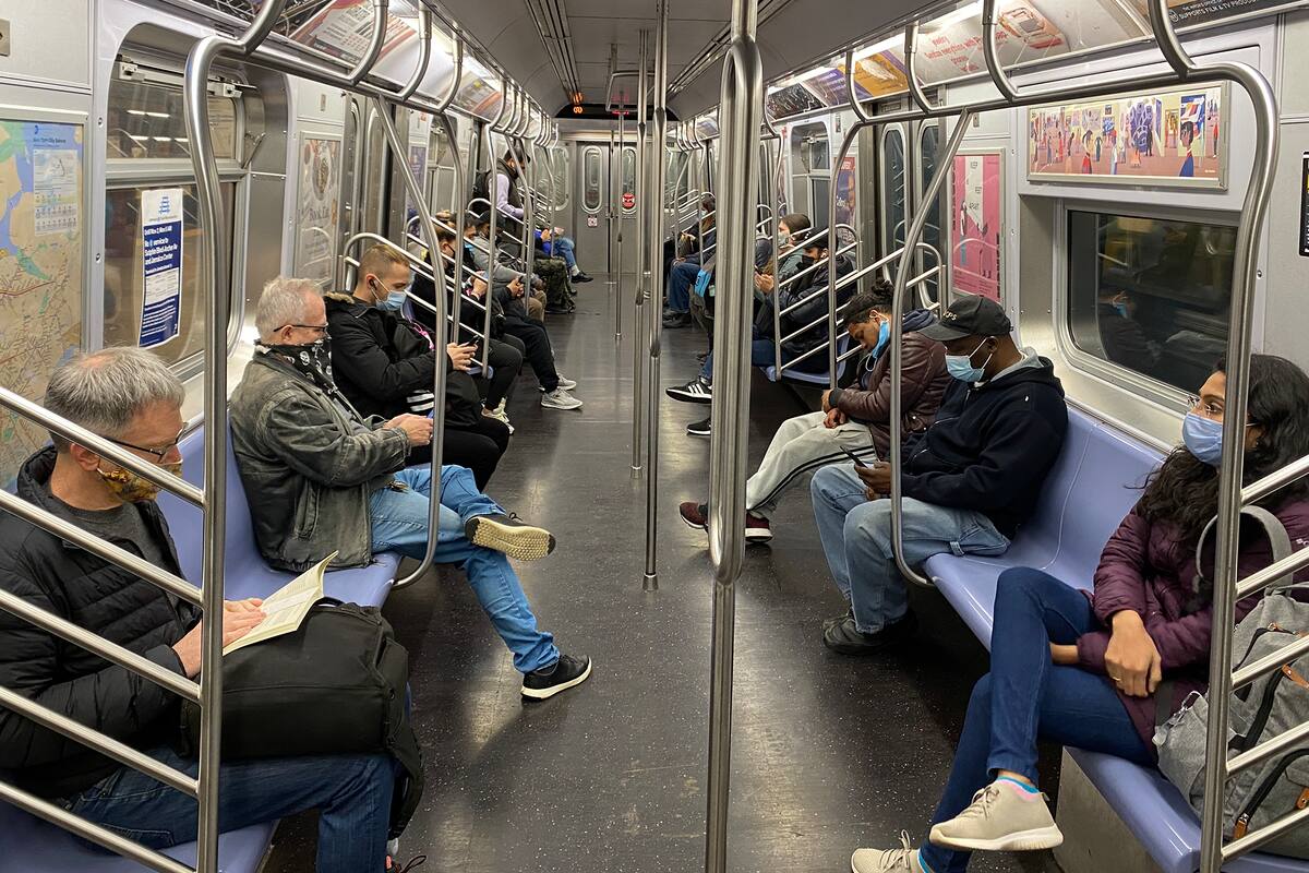 Los pasajeros viajan en el metro de la ciudad de Nueva York manteniendo la distancia social el 5 de noviembre de 2020, mientras la pandemia de coronavirus continúa en todo el mundo