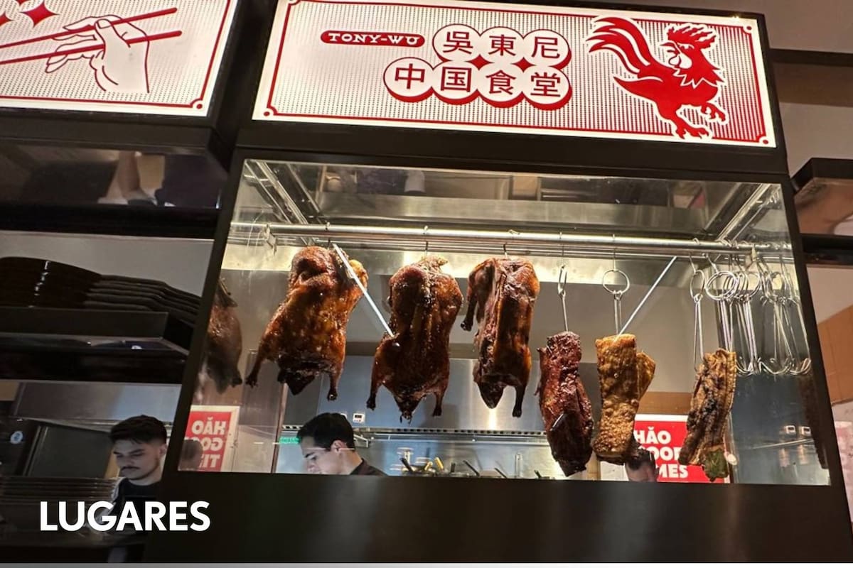 Los patos rostizados se exhiben colgados detrás de un vidrio.