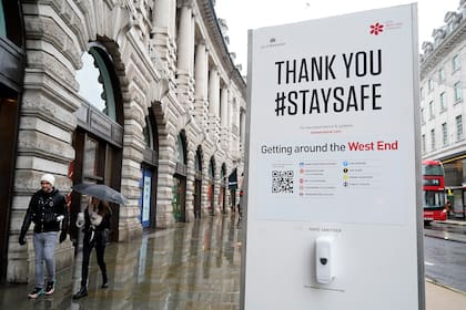 Los peatones caminan por Regent Street pasando una estación de saneamiento en Londres el 14 de enero de 2021 durante el tercer cierre del coronavirus en Gran Bretaña