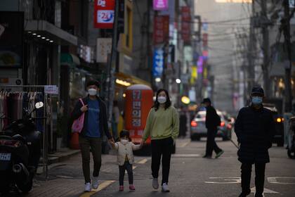 Los peatones con máscaras faciales recorren una calle de Seúl, Corea del Sur, el 16 de noviembre de 2020, en medio de la pandemia de coronavirus