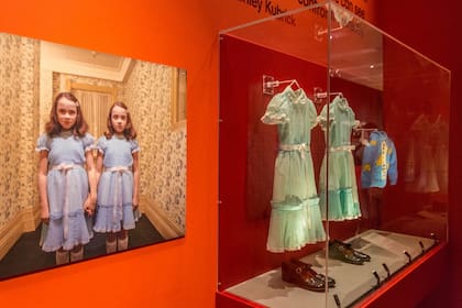 Los pequeños vestidos celestes que usaron las gemelas al final del pasillo en la película El resplandor, entre los objetos de una exposición que recordó a Kubrick, en Londres