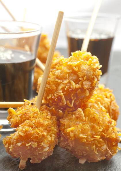 Los pinchos de pollo rebozados en copos de maíz y semillas son una de las variantes que trae el combinado de tapas de Deriva