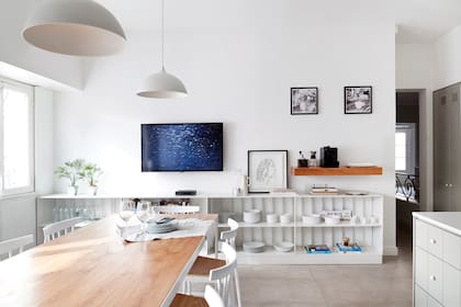 Mesa con estructura de hierro y tapa de paraíso, y sillas con asiento enchapado en madera (CDI). Los pisos de baldosas son de porcelanato de 1,20x0,60m.
