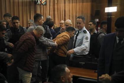 Los policías condenados a prisión perpetua, en el momento de ser retirados esposados de la sala de audiencia
