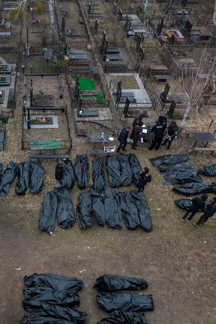 Los policías trabajan en el proceso de identificación tras el asesinato de civiles en Bucha, antes de enviar los cuerpos a la morgue, en las afueras de Kiev, Ucrania