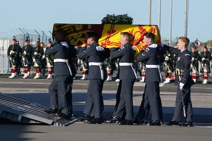 Los portadores del féretro del Queen's Color Squadron de la Royal Air Force (RAF) llevan el ataúd de la reina Isabel II, envuelto en el estandarte real de Escocia, en un avión C17 de la RAF en el aeropuerto de Edimburgo