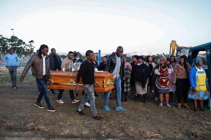 Los portadores del féretro llevan el ataúd de Thembinkosi Silwane durante su entierro en el cementerio Heaven Hills en East London, el 6 de julio. (Photo by Phill Magakoe / AFP)
