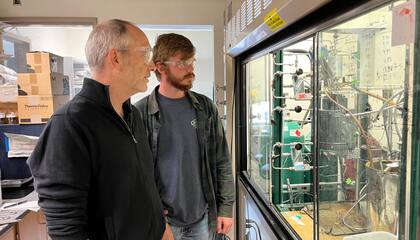 Los químicos John Hartwig y RJ Conk discuten el aparato experimental que reduce los plásticos a sus precursores monómeros, que luego se pueden usar para fabricar nuevos plásticos (Crédito: Robert Sanders, Universidad de California en Berkeley)
