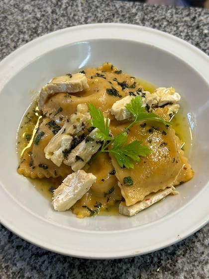 Los raviolones de calabaza y cebollitas caramelizada, con manteca de hierbas y queso brie fundido.