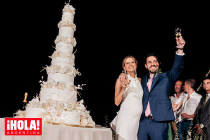 Los recién casados levantan sus copas antes de cortar la torta de bodas de siete pisos.