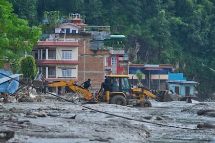Los rescatistas utilizan excavadoras para llegar a viviendas sumergidas tras las inundaciones repentinas a lo largo del río Trishuli, en el distrito de Nuwakot, Nepal