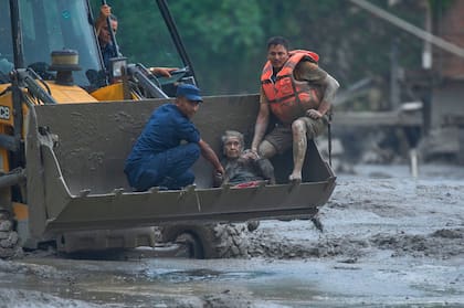 Los rescatistas utilizan una excavadora para trasladar a salvo a una víctima de las inundaciones repentinas a lo largo del río Trishuli, en el distrito de Nuwakot, Nepal