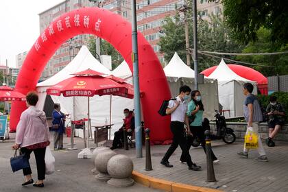 Los residentes caminan por un centro de vacunación en Beijing