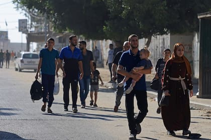 Los residentes de la Franja de Gaza huyen de sus hogares para alejarse de la frontera con Israel después de que se dispararan ráfagas de cohetes desde el enclave costero hacia Israel el 7 de octubre de 2023