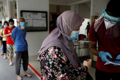 Los residentes de una urbanización pública hacen cola para las pruebas obligatorias de coronavirus en Singapur el 21 de mayo de 2021