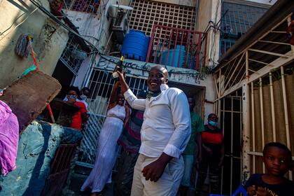 Los residentes del distrito Cassenda de Luanda el 20 de mayo de 2020 celebran después de que la Directora Nacional de Salud Pública, Helga Freitas, levantara una orden de cuarentena de dos semanas