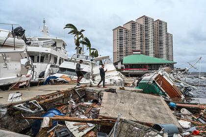 Los residentes inspeccionan los daños a un puerto deportivo mientras los barcos están parcialmente sumergidos después del huracán Ian en Fort Myers, Florida, el 29 de septiembre de 2022