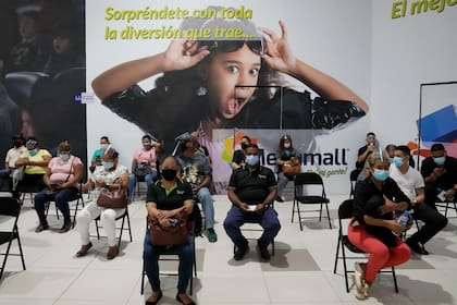 Los residentes quedan en observación después de recibir inyecciones de la vacuna AstraZeneca para el COVID-19 en un centro comercial en las afueras de la ciudad de Panamá, el miércoles 9 de junio de 2021. (AP Foto/Arnulfo Franco)