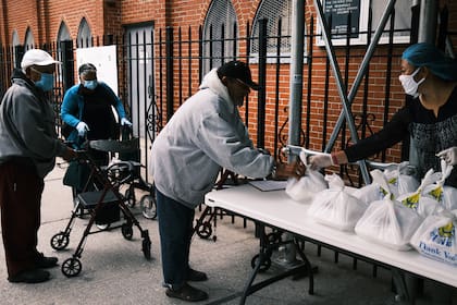 Los residentes reciben una comida preparada en la Iglesia Cristiana de Tesalónica durante una distribución el 22 de octubre de 2020 en la ciudad de Nueva York