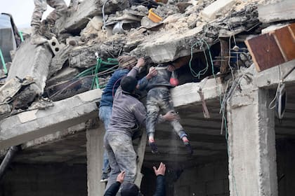 Los residentes recuperan a una niña herida de los escombros de un edificio derrumbado luego de un terremoto en la ciudad de Jandaris, en el campo de la ciudad de Afrin, en el noroeste de Siria, en la parte rebelde de la provincia de Aleppo, el 6 de febrero de 2023