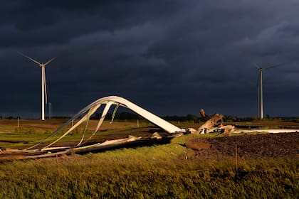 Los restos de un molino de viento dañado por un tornado se ven en el suelo en un campo el martes 21 de mayo de 2024, cerca de Prescott, Iowa. (AP Foto/Charlie Neibergall)