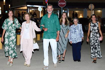 Los reyes Felipe y Letizia, sus hijas Leonor y Sofía, la reina Sofía y su hermana, la princesa Irene de Grecia, caminan por las calles de Mallorca después de cenar en el restaurante ola del Mar de Portitxol. Para esa ocasión, la Reina eligió un vestido estampado en blanco y negro que combinó con un bolso de mano Roba de Llengües, Leonor lució un diseño de largo midi en gris con ribetes negros, Sofía también prefirió un estilismo jovial con un vestido verde estampado y el Rey optó por el verde para su camisa, que combinó con pantalones blancos y zapatillas de la firma mallorquina Yuccs.