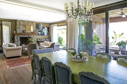 Los sillones, absolutos protagonistas del living. Además, sillas materas salteñas que les regalaron para su casamiento, una mesa ratona de lapacho (Negro), lámparas colgantes de tela (Mesopotamia) y una fotografía en blanco y negro de Celine Frers.
