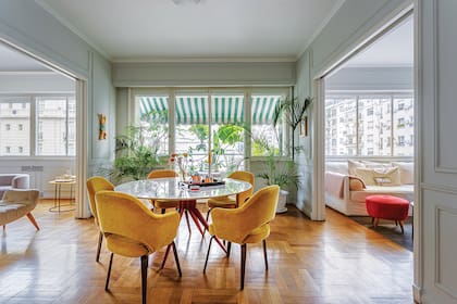 El comedor está en medio de dos livings, uno de uso formal y otro más de estar, para ver la televisión o enfrascarse en lo que ofrece la biblioteca. Los sillones (Fábrica de Clásicos) tapizados en terciopelo amarillo (Casa Almacén) contrastan con las patas rojas de la mesa (Mercado de Pulgas).