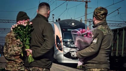 Los soldados esperando en la estación con ramos de flores se han convertido en una imagen habitual en Ucrania