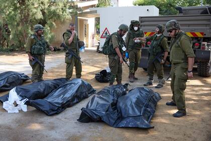 Los soldados israelíes se preparan para retirar los cuerpos de sus compatriotas, muertos durante un ataque de militantes palestinos, en Kfar Aza, al sur de Israel, en la frontera con la Franja de Gaza, el 10 de octubre de 2023