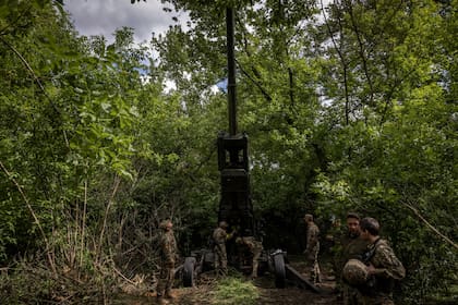 Los soldados ucranianos colocan un obús M777 en un grupo de árboles para camuflarse en la región de Donetsk, Ucrania, el domingo 22 de mayo de 2022. (Ivor Prickett/The New York Times)
