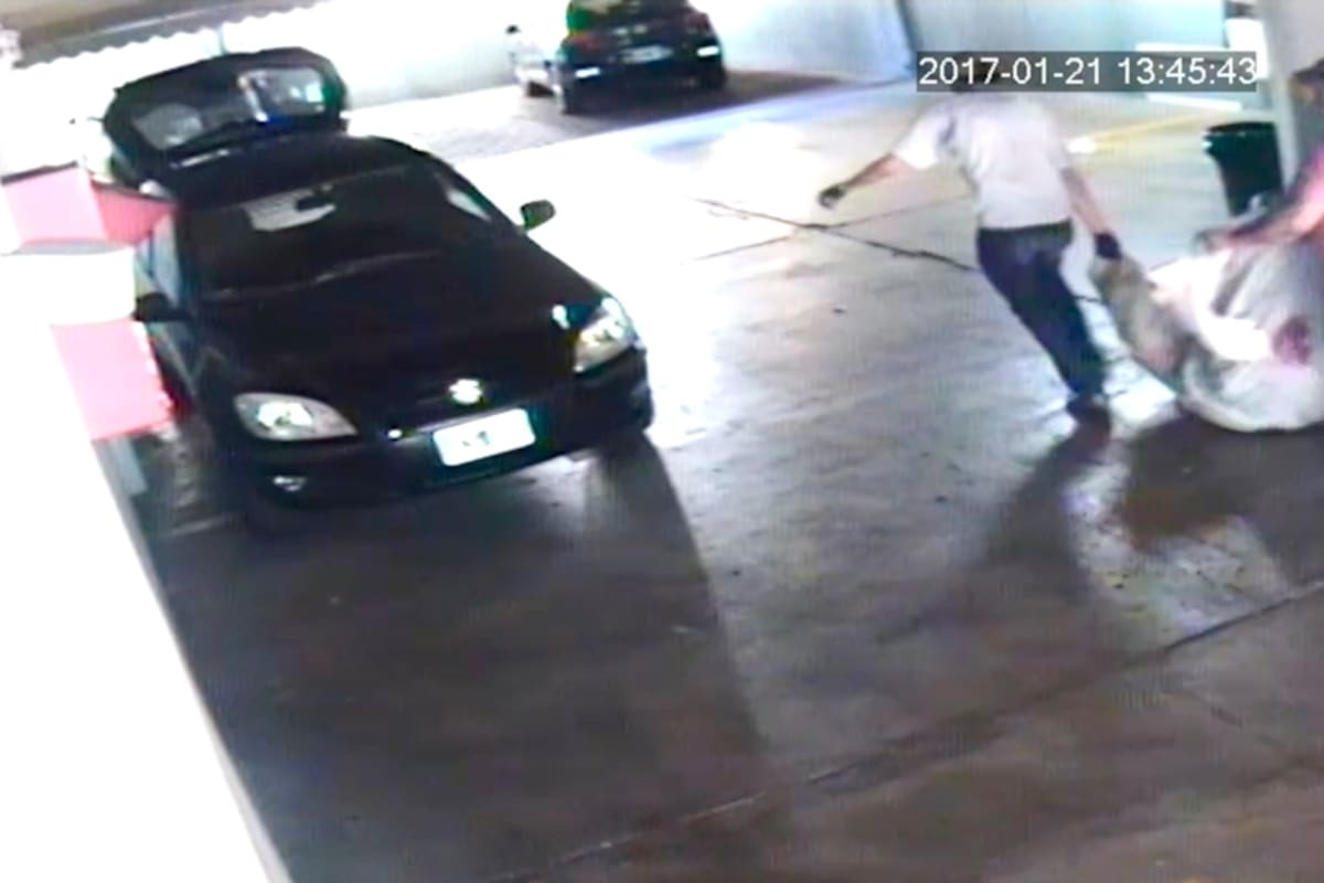 Los sospechosos arrastran el bulto hacia el auto