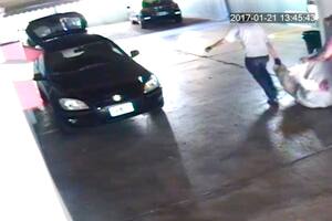 Los sospechosos arrastran el bulto hacia el auto