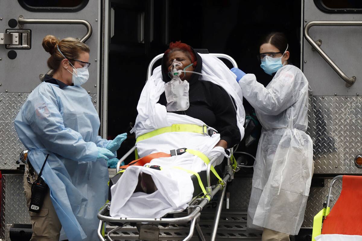 Los técnicos médicos de emergencia (EMT) que usan engranajes protectores llevan a un paciente enfermo a una ambulancia en espera durante el brote de la enfermedad por coronavirus (COVID-19) en la ciudad de Nueva York, Nueva York, EE. UU