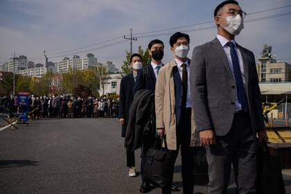 Los testigos de Jehová y los objetores de conciencia de Corea del Sur al servicio militar obligatorio se alinean para ingresar a una instalación correccional para comenzar a capacitarse como administradores, en Daejeon el 26 de octubre de 2020