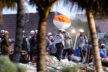 Los trabajadores de búsqueda y rescate buscan sobrevivientes entre los escombros en el sitio del derrumbe del edificio Champlain Towers South Condo en Surfside el miércoles