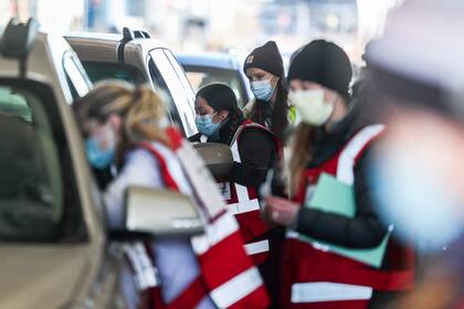 Los trabajadores de la salud de UCHealth reciben pacientes para su segunda dosis de una vacuna Covid-19 durante un evento de vacunación masiva en el estacionamiento de Coors Field en Denver, Colorado