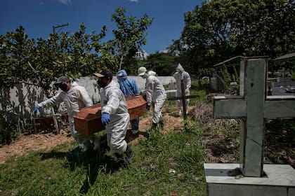 Los trabajadores llevan un ataúd de una persona que murió por coronavirus en el cementerio municipal Recanto da Paz, en Breves, en el estado brasileño de Pará, el 7 de junio de 2020